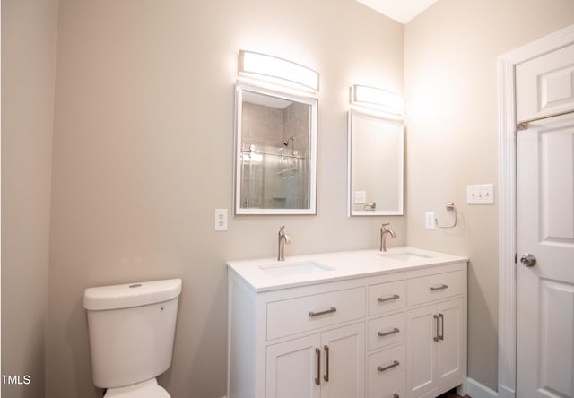 bathroom with tiled shower, vanity, and toilet