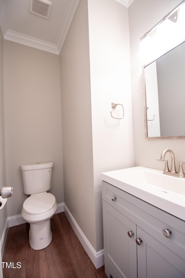 bathroom featuring toilet, wood-type flooring, vanity, and crown molding