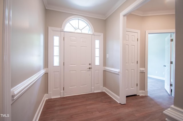 foyer entrance with ornamental molding and dark hardwood / wood-style flooring