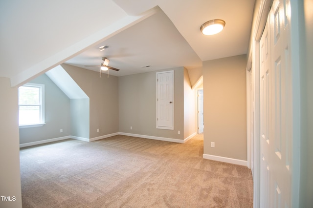 additional living space with ceiling fan, light colored carpet, and lofted ceiling