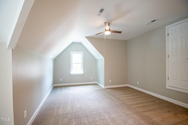 additional living space with lofted ceiling, light colored carpet, and ceiling fan