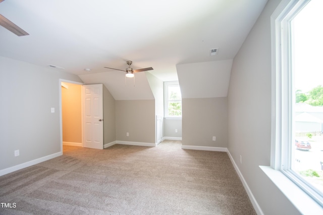 additional living space featuring ceiling fan, light colored carpet, and lofted ceiling