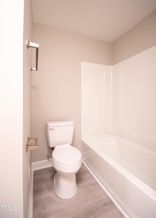 bathroom with toilet, shower / washtub combination, and hardwood / wood-style floors