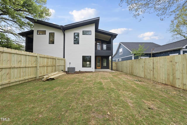 back of property with a balcony, central AC, and a lawn