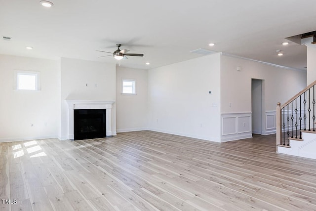 unfurnished living room featuring ceiling fan, light wood-type flooring, and plenty of natural light