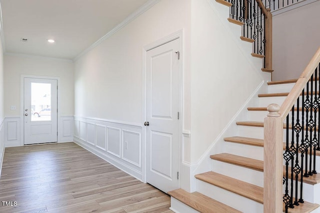 foyer entrance featuring light wood-type flooring and crown molding