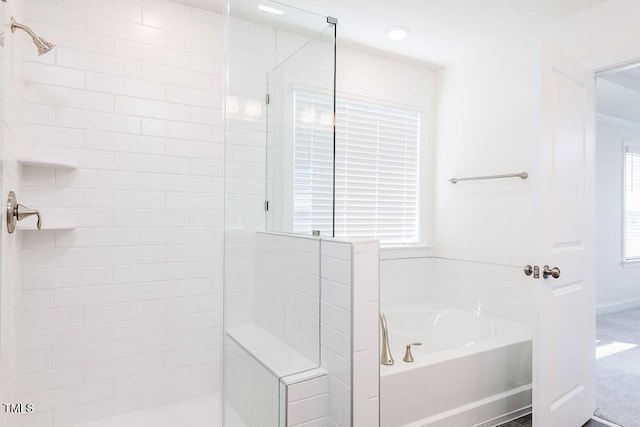 bathroom featuring shower with separate bathtub