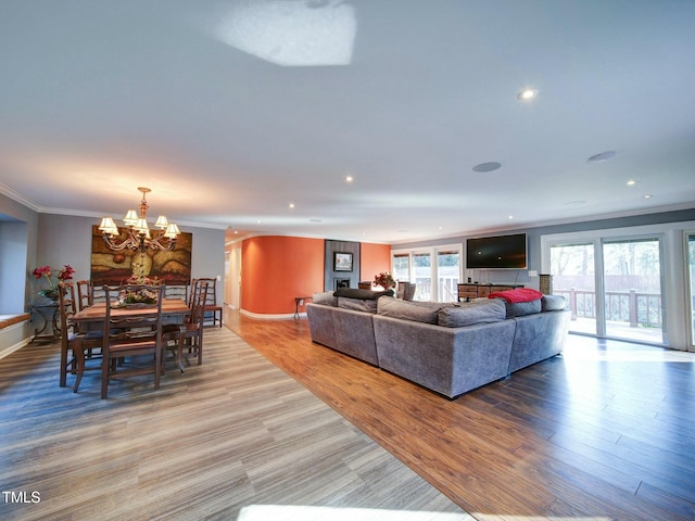 living room featuring a chandelier, light hardwood / wood-style floors, and ornamental molding