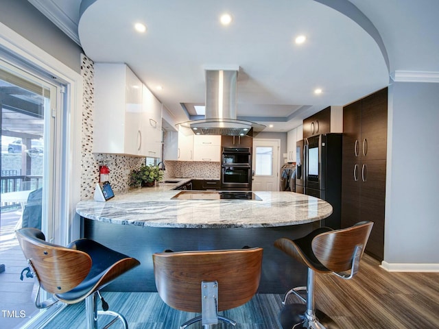 kitchen with white cabinetry, island range hood, kitchen peninsula, black appliances, and sink