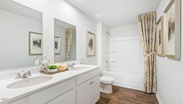 full bathroom featuring toilet, hardwood / wood-style flooring, shower / bath combo with shower curtain, and vanity