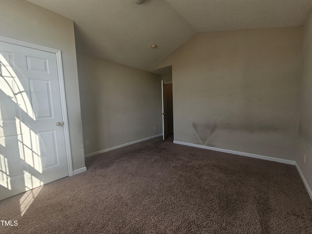 carpeted empty room featuring vaulted ceiling