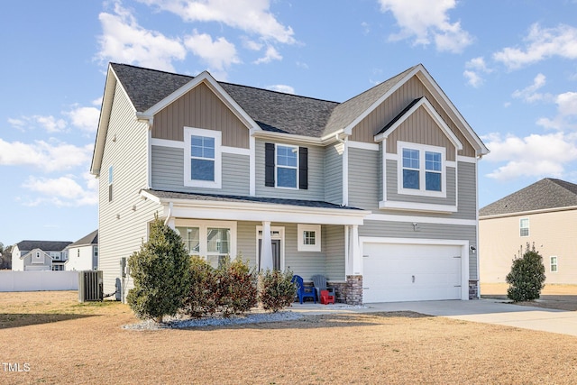 craftsman-style home with covered porch, central AC, a garage, and a front yard