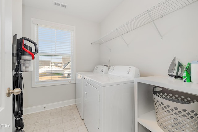 washroom featuring a healthy amount of sunlight, light tile patterned flooring, and washing machine and clothes dryer