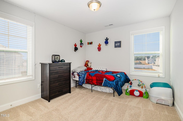 carpeted bedroom with multiple windows