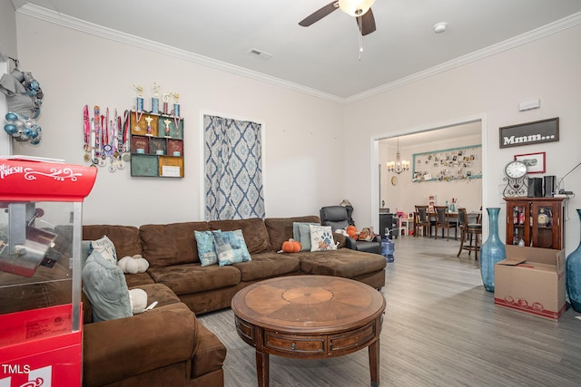 living room featuring ceiling fan with notable chandelier, ornamental molding, and hardwood / wood-style flooring