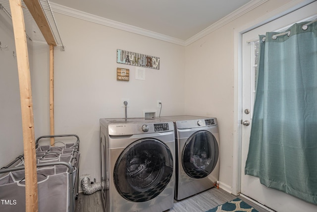 laundry room featuring hardwood / wood-style flooring, washer and dryer, and ornamental molding