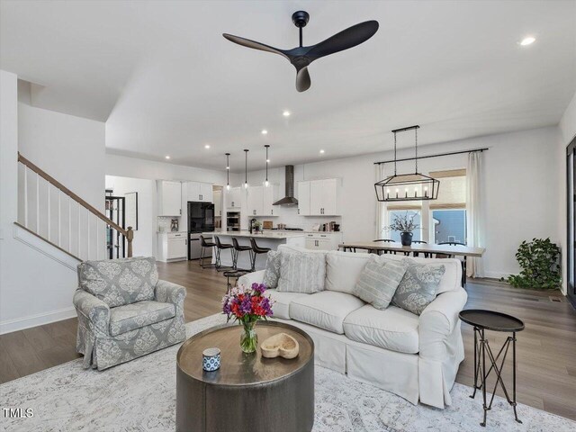 living room with ceiling fan and light hardwood / wood-style flooring