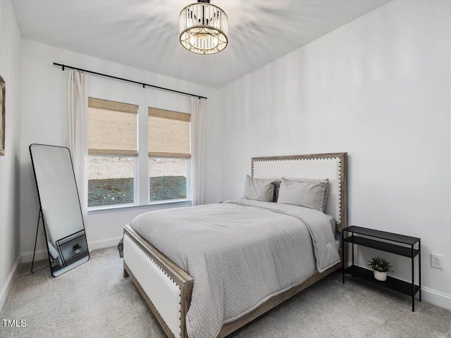 bedroom with a notable chandelier and light carpet