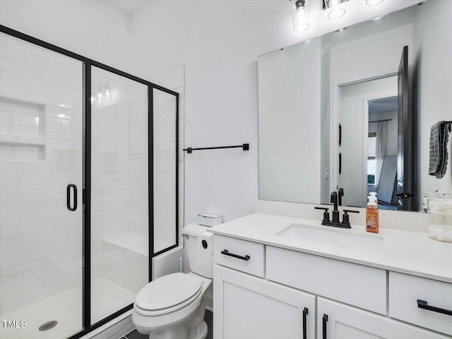 bathroom with walk in shower, vanity, and toilet