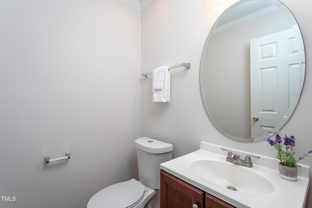 bathroom with toilet, crown molding, and vanity