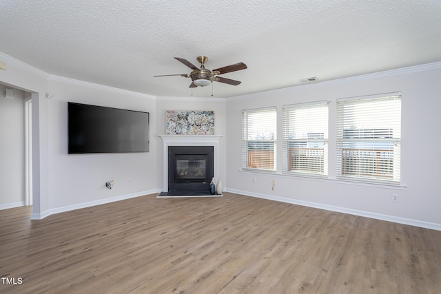 unfurnished living room featuring a textured ceiling, ceiling fan, ornamental molding, and light hardwood / wood-style floors