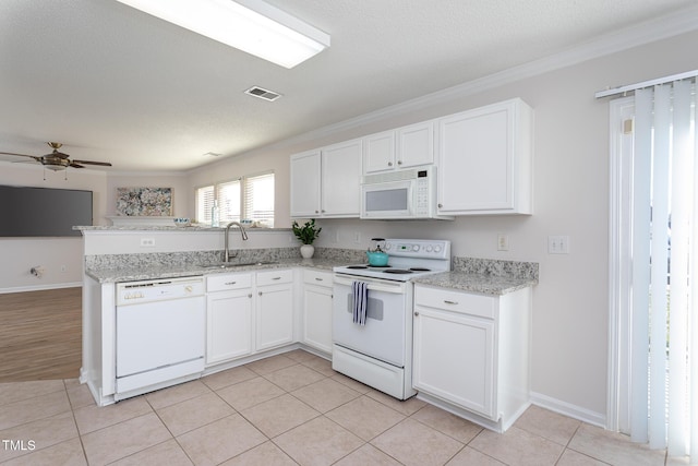 kitchen with white cabinets, light tile patterned floors, sink, and white appliances