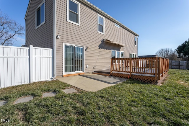 rear view of house featuring a wooden deck, a yard, and a patio