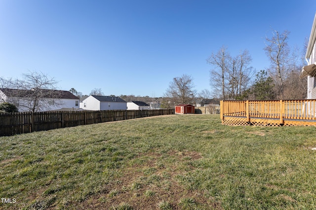 view of yard featuring a wooden deck and a storage unit