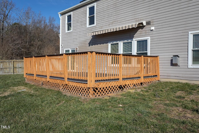 rear view of property with a wooden deck and a lawn