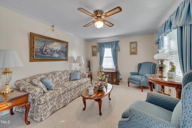 living room featuring ceiling fan, ornamental molding, and carpet flooring