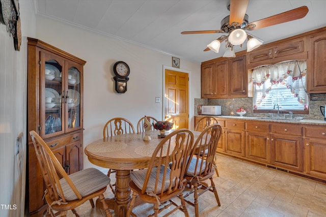 dining area featuring sink, ceiling fan, and crown molding