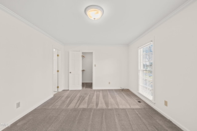 empty room with crown molding and carpet flooring