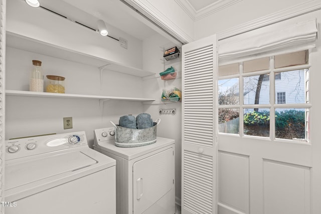 clothes washing area featuring ornamental molding and washing machine and dryer