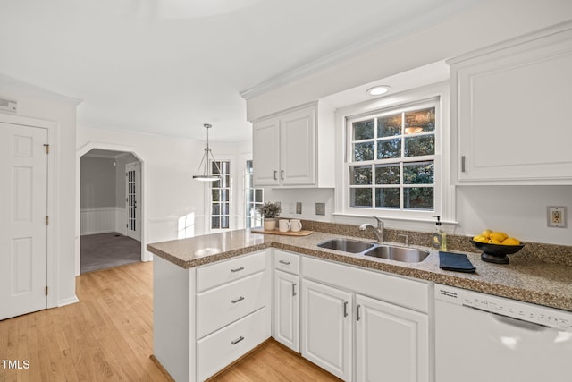 kitchen featuring white cabinetry, dishwasher, sink, hanging light fixtures, and kitchen peninsula