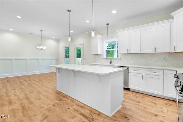 kitchen featuring white cabinets, appliances with stainless steel finishes, and pendant lighting