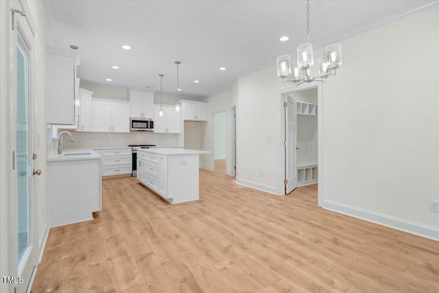 kitchen featuring a center island, decorative light fixtures, stainless steel appliances, backsplash, and white cabinets