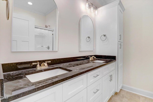 bathroom with vanity, tile patterned floors, ornamental molding, and a shower with shower door