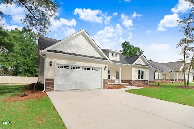 craftsman inspired home featuring a garage and a front lawn