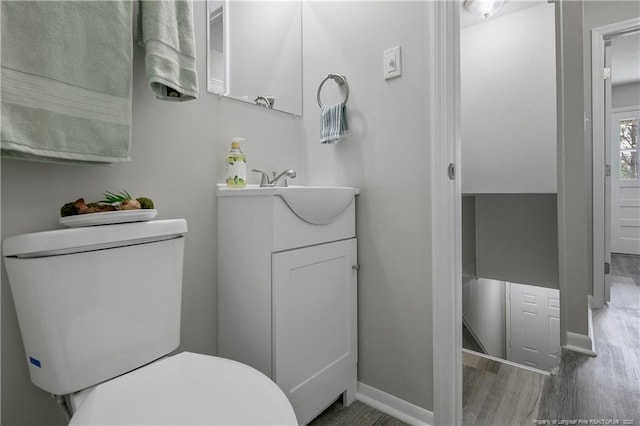 bathroom with hardwood / wood-style floors, toilet, and vanity