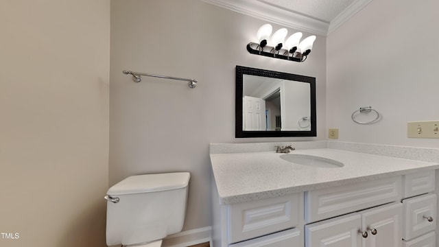 bathroom with ornamental molding, vanity, and toilet