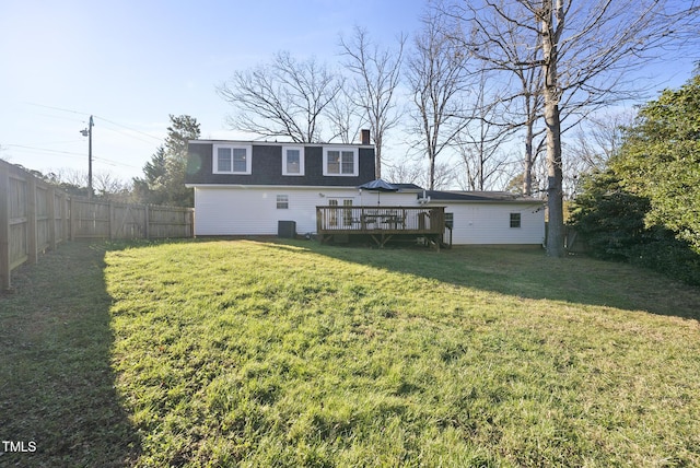 rear view of property featuring central AC unit, a wooden deck, and a yard