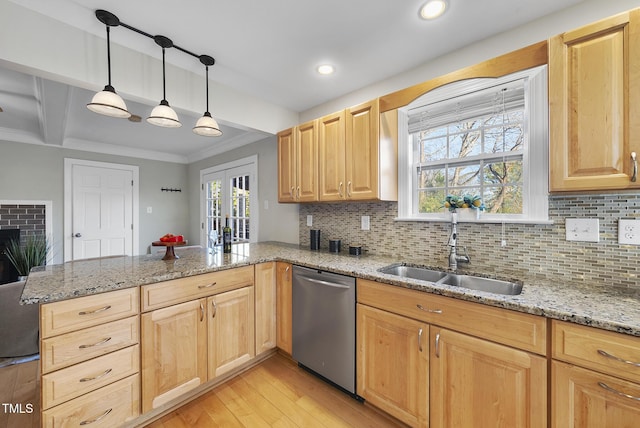 kitchen featuring decorative light fixtures, stainless steel dishwasher, kitchen peninsula, sink, and light stone countertops