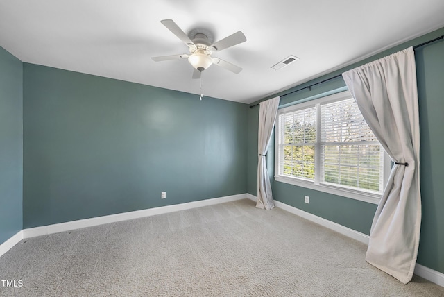 carpeted spare room featuring ceiling fan