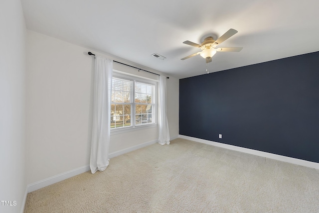 spare room with ceiling fan and light colored carpet