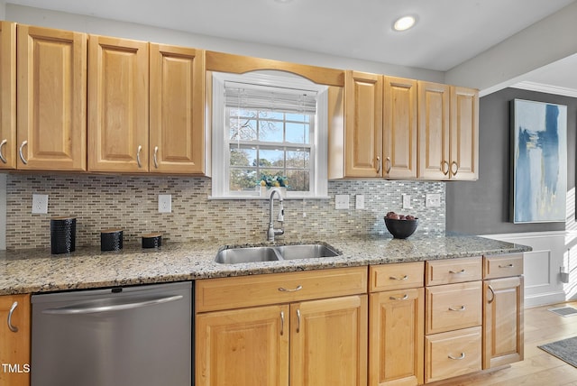 kitchen with light stone countertops, dishwasher, backsplash, and sink