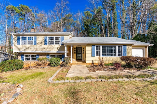 tri-level home with a front yard and a garage