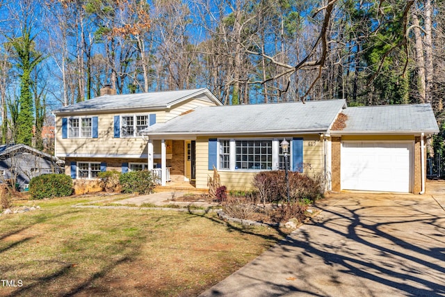 tri-level home with a garage, covered porch, and a front lawn