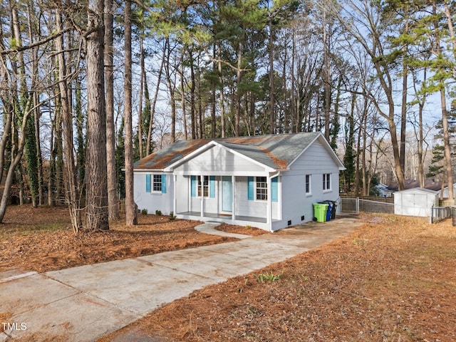 view of front of house with covered porch and a shed