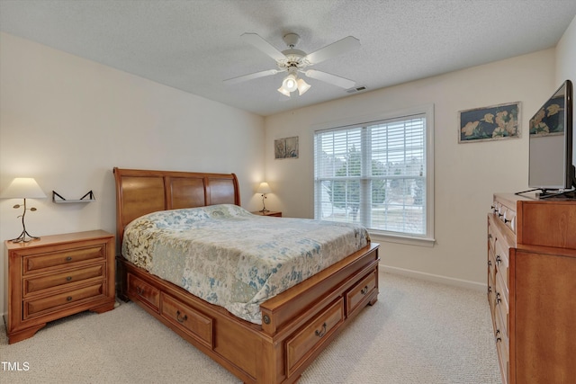 carpeted bedroom featuring ceiling fan and a textured ceiling