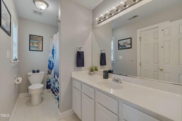 bathroom with toilet, vanity, tile patterned floors, and a textured ceiling